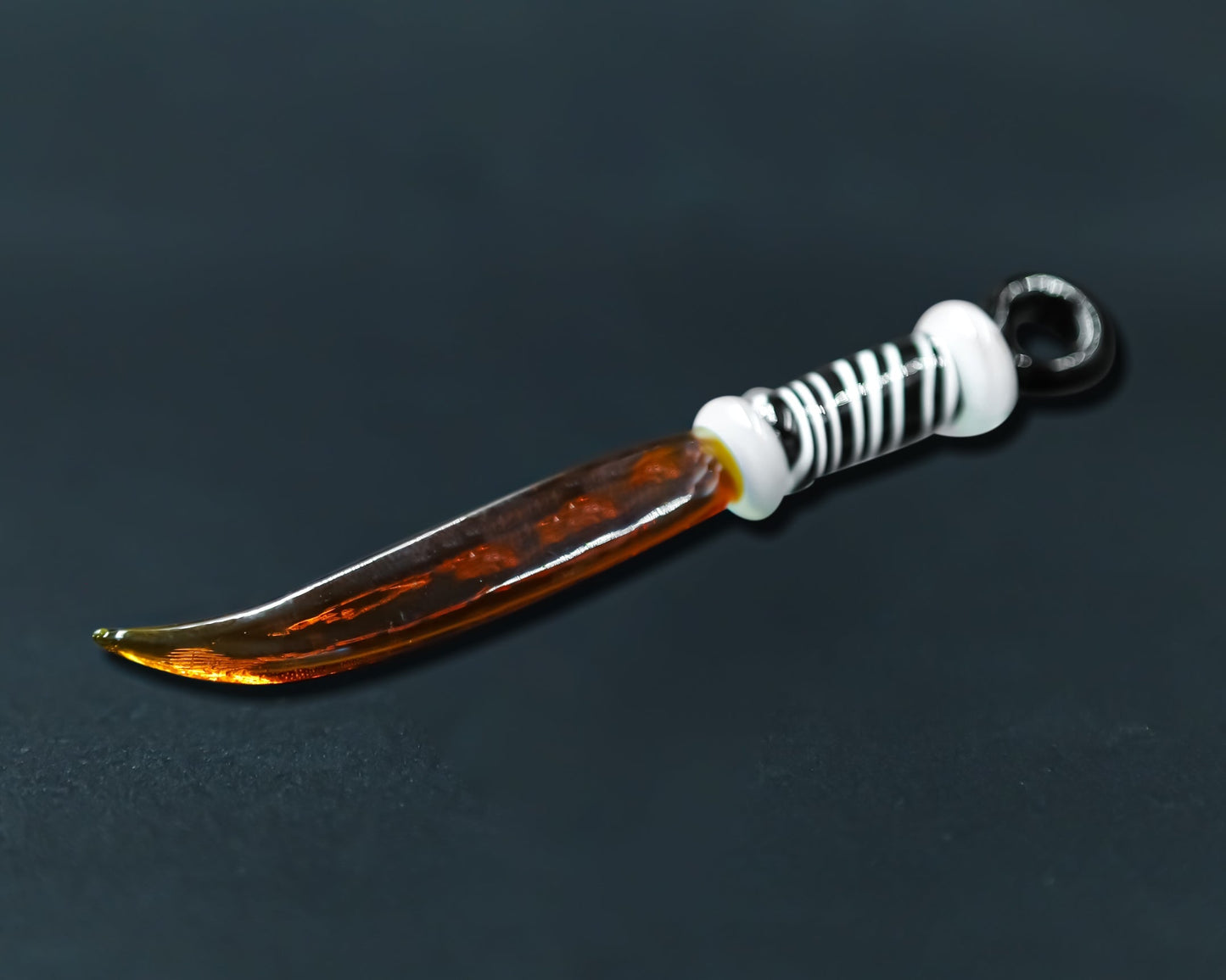 Glass sword dab tool featuring an amber blade and white handle for ultimate dabbing bliss